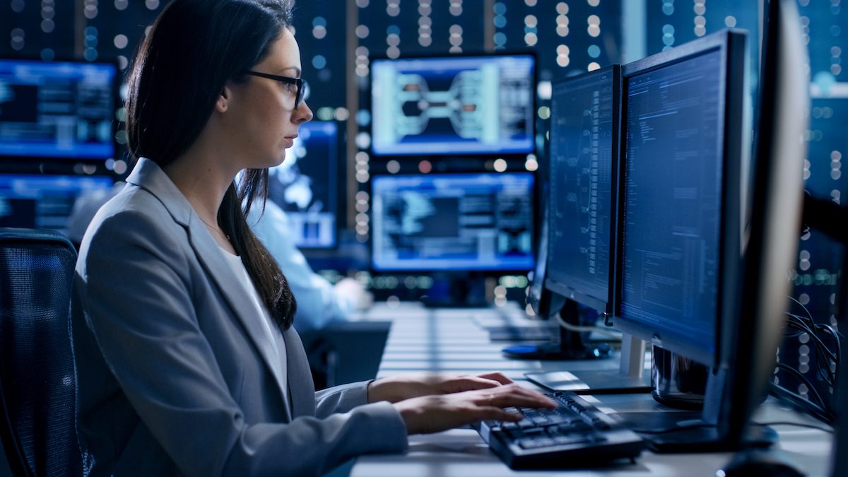 Woman in front of computer with screens in background